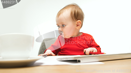 Image of Happy child baby girl toddler sitting with keyboard of computer isolated on a white background