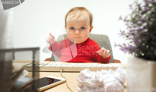Image of Happy child baby girl toddler sitting with keyboard of computer isolated on a white background