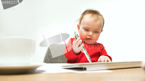 Image of Happy child baby girl toddler sitting with keyboard of computer isolated on a white background