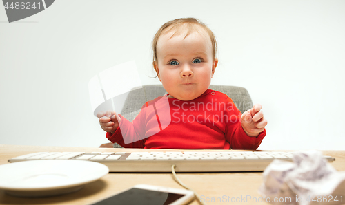 Image of Happy child baby girl toddler sitting with keyboard of computer isolated on a white background