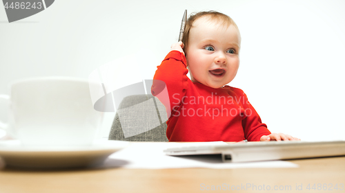 Image of Happy child baby girl toddler sitting with keyboard of computer isolated on a white background