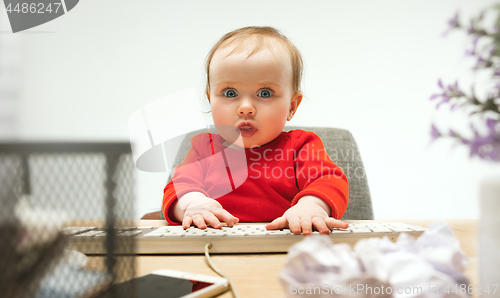 Image of Happy child baby girl toddler sitting with keyboard of computer isolated on a white background