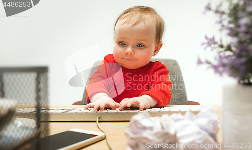 Image of Happy child baby girl toddler sitting with keyboard of computer isolated on a white background