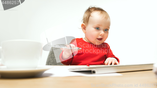 Image of Happy child baby girl toddler sitting with keyboard of computer isolated on a white background