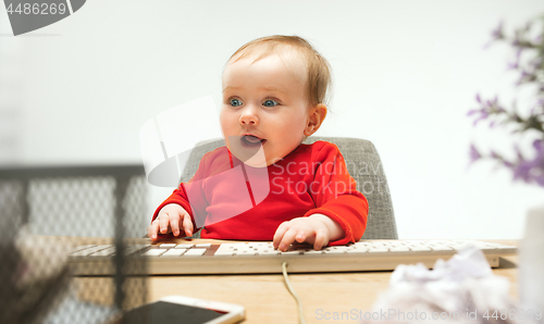 Image of Happy child baby girl toddler sitting with keyboard of computer isolated on a white background
