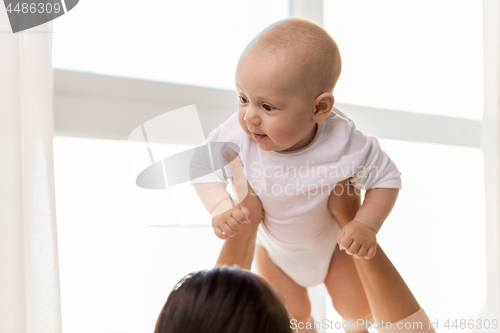 Image of happy mother playing with little baby boy at home