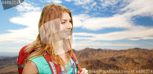 Image of smiling woman with backpack over mountains