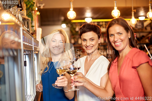 Image of happy women drinking wine at bar or restaurant