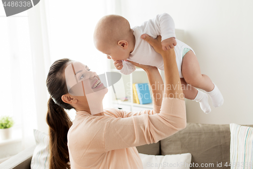 Image of happy mother playing with little baby boy at home