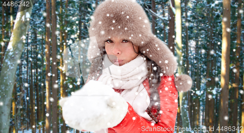 Image of woman in fur hat with snow over winter forest