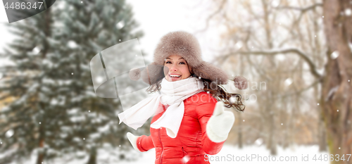 Image of happy woman in fur hat over winter forest