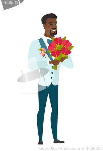 Image of African groom holding a bouquet of flowers.