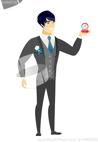 Image of Young groom holding wedding ring in box.