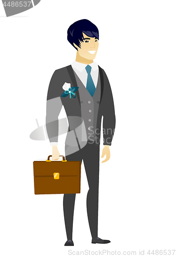 Image of Asian groom holding briefcase.