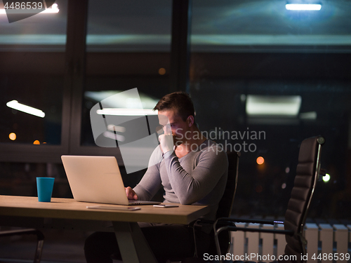 Image of man working on laptop in dark office