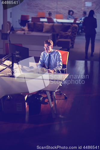 Image of man working on computer in dark office