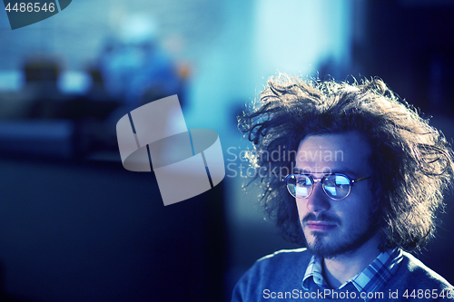 Image of man working on computer in dark office