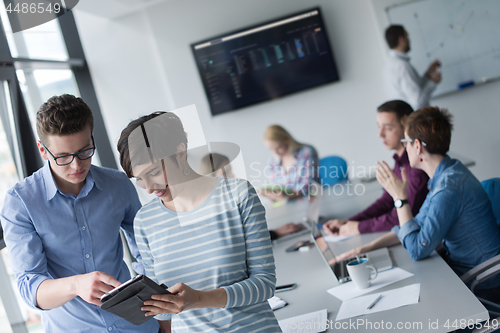 Image of Two Business People Working With Tablet in office