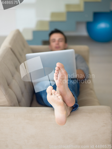 Image of Man using laptop in living room