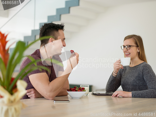 Image of couple enjoying morning coffee and strawberries