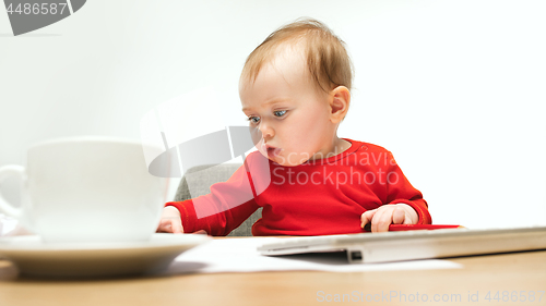 Image of Happy child baby girl toddler sitting with keyboard of computer isolated on a white background