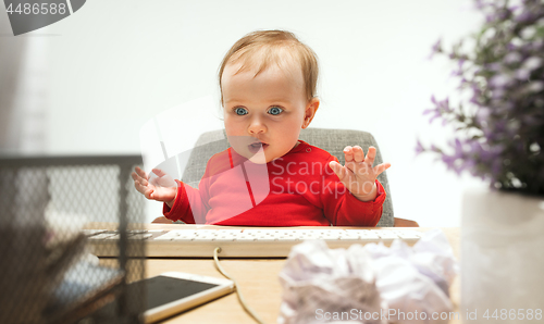 Image of Happy child baby girl toddler sitting with keyboard of computer isolated on a white background