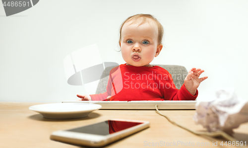 Image of Happy child baby girl toddler sitting with keyboard of computer isolated on a white background
