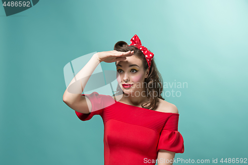 Image of Beautiful young woman with pinup make-up and hairstyle. Studio shot on white background