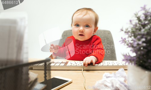 Image of Happy child baby girl toddler sitting with keyboard of computer isolated on a white background