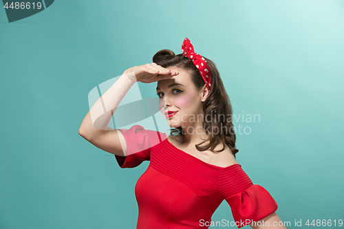 Image of Beautiful young woman with pinup make-up and hairstyle. Studio shot on white background