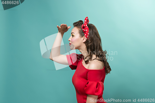 Image of Beautiful young woman with pinup make-up and hairstyle. Studio shot on white background