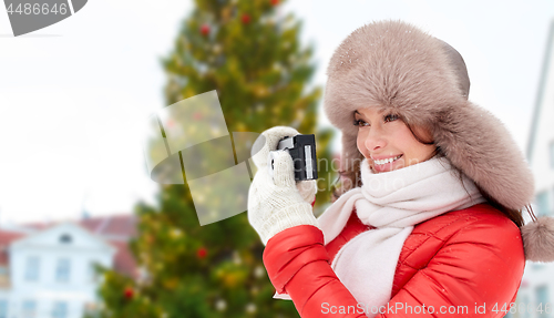 Image of woman with camera over christmas tree in tallinn