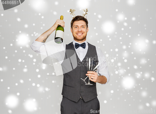 Image of man with bottle of champagne at christmas party