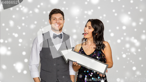 Image of happy couple with big arrow at party