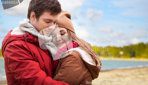 Image of happy teenage couple hugging over autumn beach