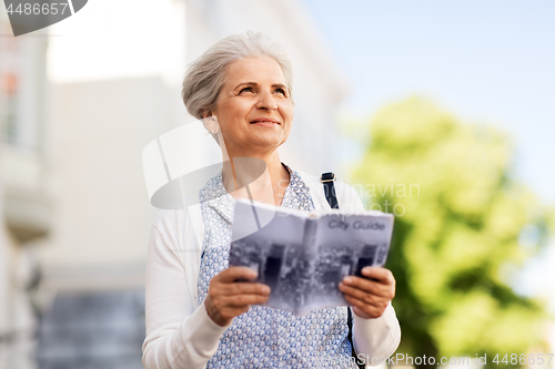 Image of senior woman or tourist with city guide outdoors