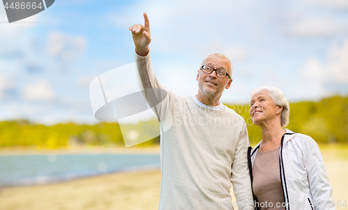 Image of happy senior couple over beach background