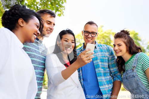 Image of happy friends with smartphone at summer park