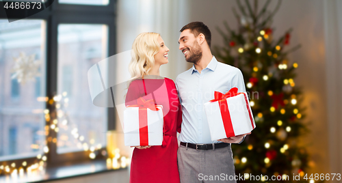 Image of happy couple with christmas gifts at home