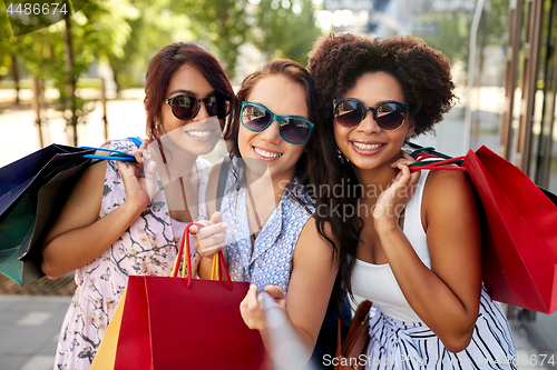 Image of happy women with shopping bags in city