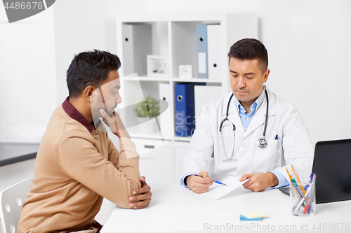 Image of doctor showing prescription to patient at clinic