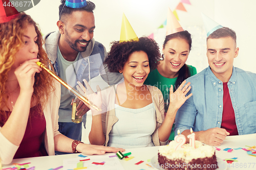 Image of team greeting colleague at office birthday party