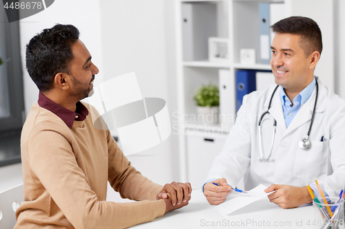 Image of doctor showing prescription to patient at clinic