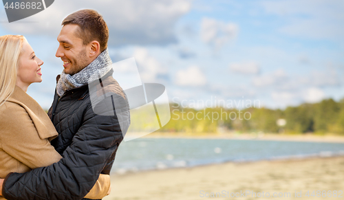 Image of happy couple hugging over autumn beach