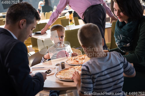 Image of Young parents enjoying lunch time with their children