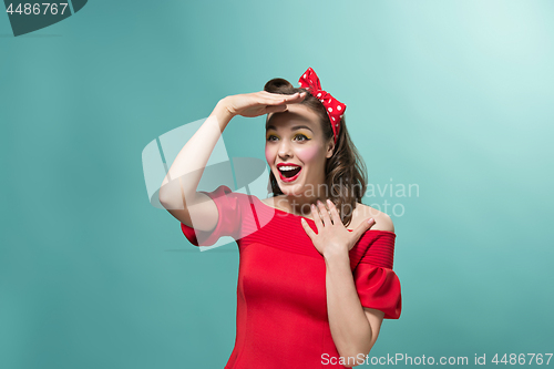 Image of Beautiful young woman with pinup make-up and hairstyle. Studio shot on white background