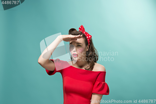Image of Beautiful young woman with pinup make-up and hairstyle. Studio shot on white background
