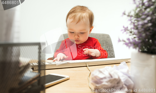 Image of Happy child baby girl toddler sitting with keyboard of computer isolated on a white background