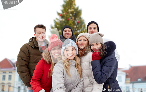 Image of happy friends over christmas tree in old tallinn