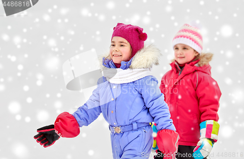 Image of happy little girls in winter clothes outdoors